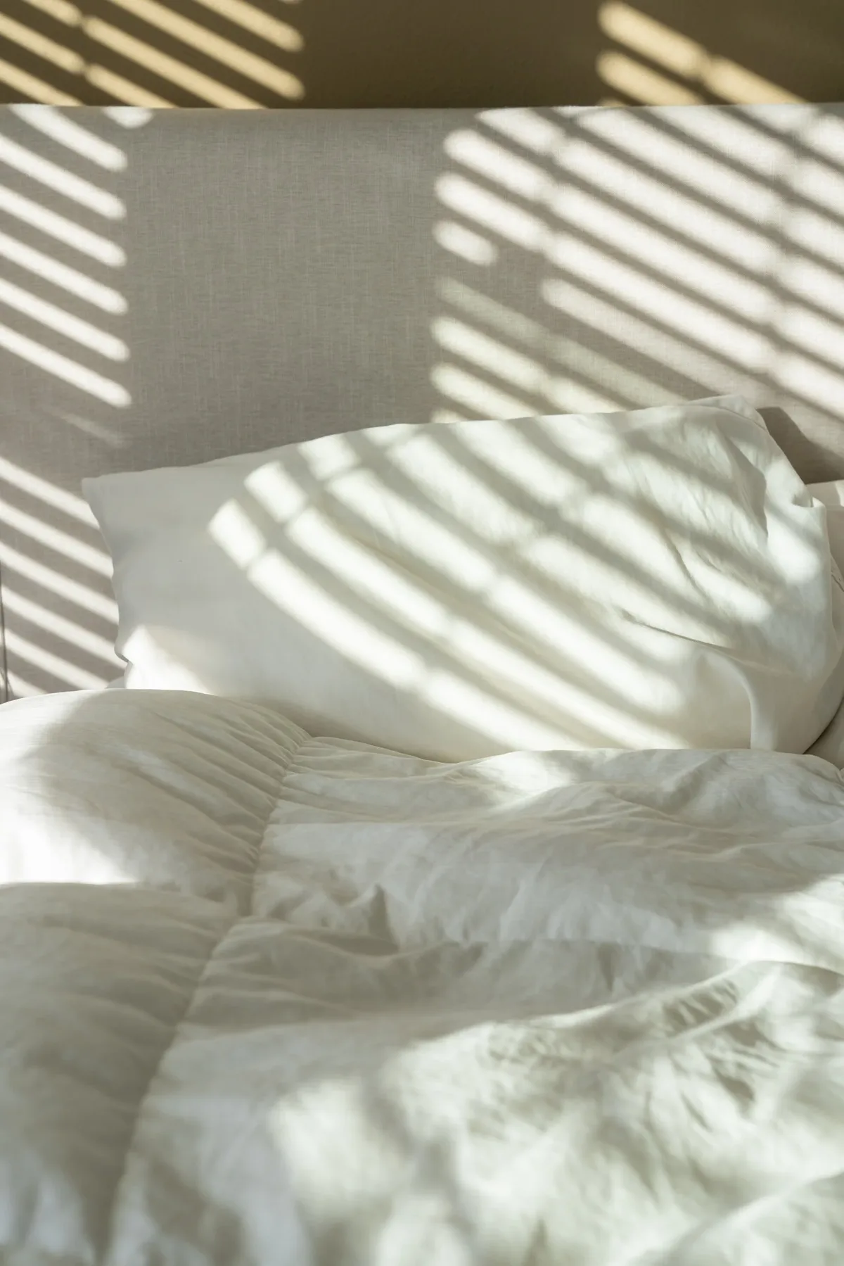 Morning light falling across white hotel linens